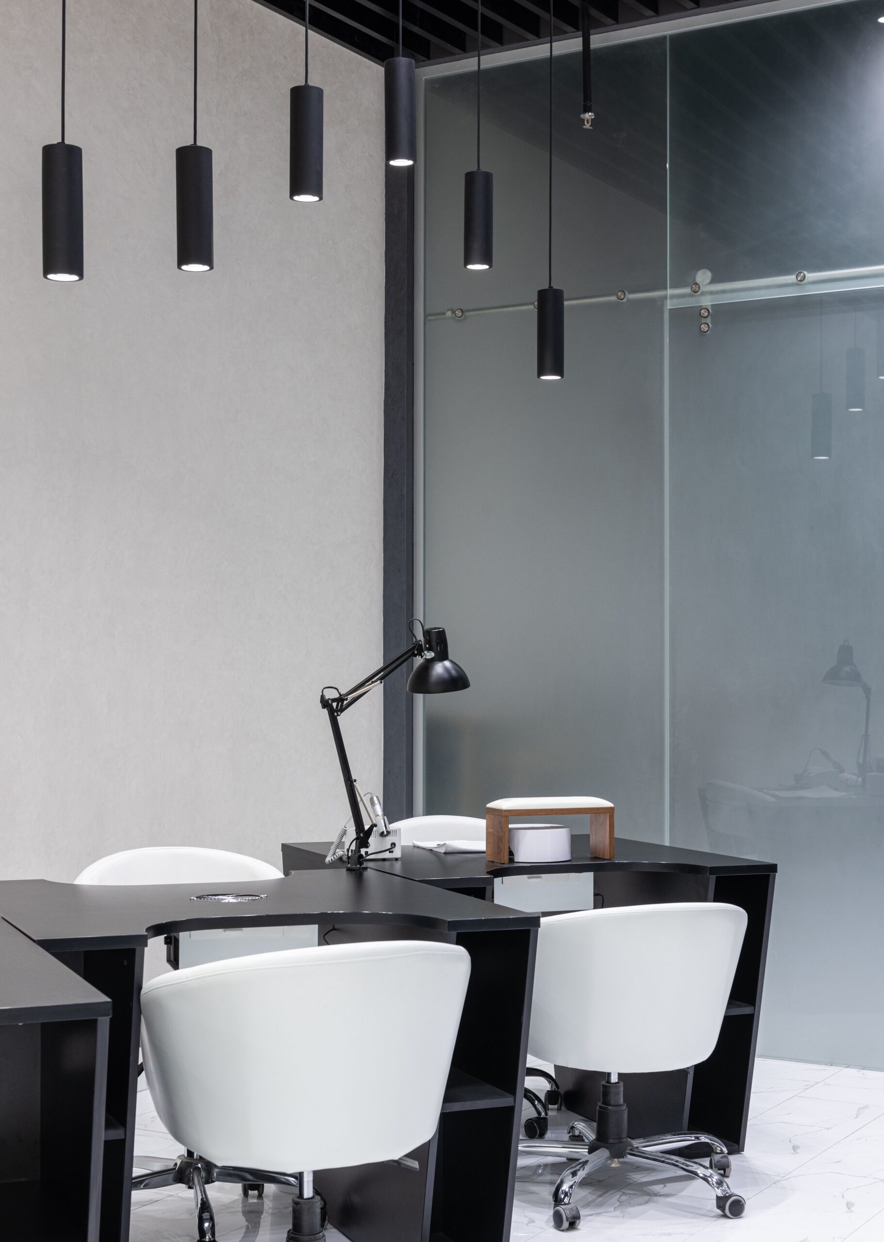 Modern executive workspace with elegant dark furniture and pendant lighting.